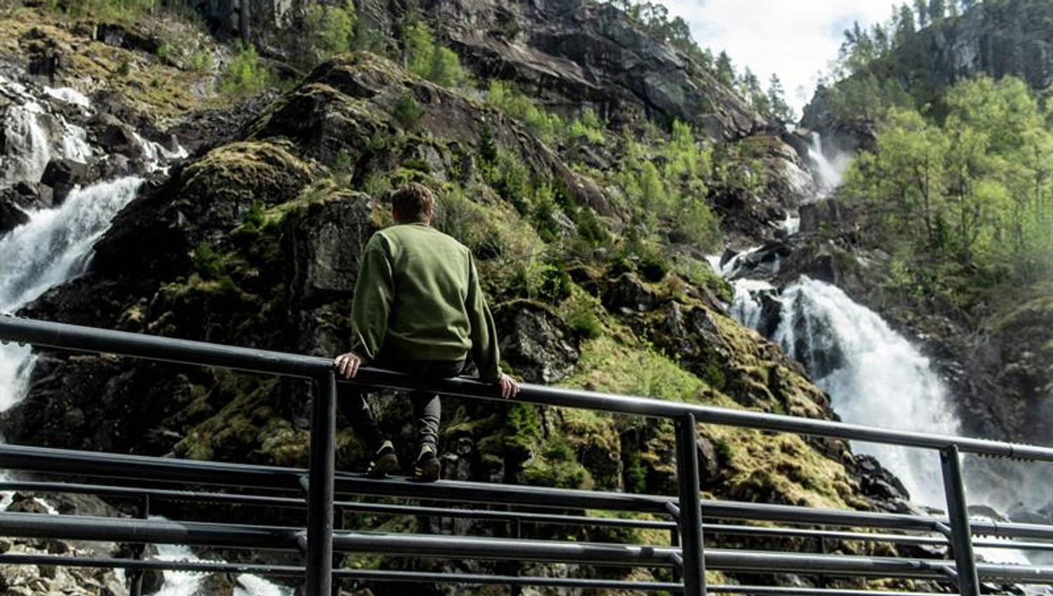 Mann nyt utsikta frå rekkverket ved Låtefoss i Hardanger, Noreg.