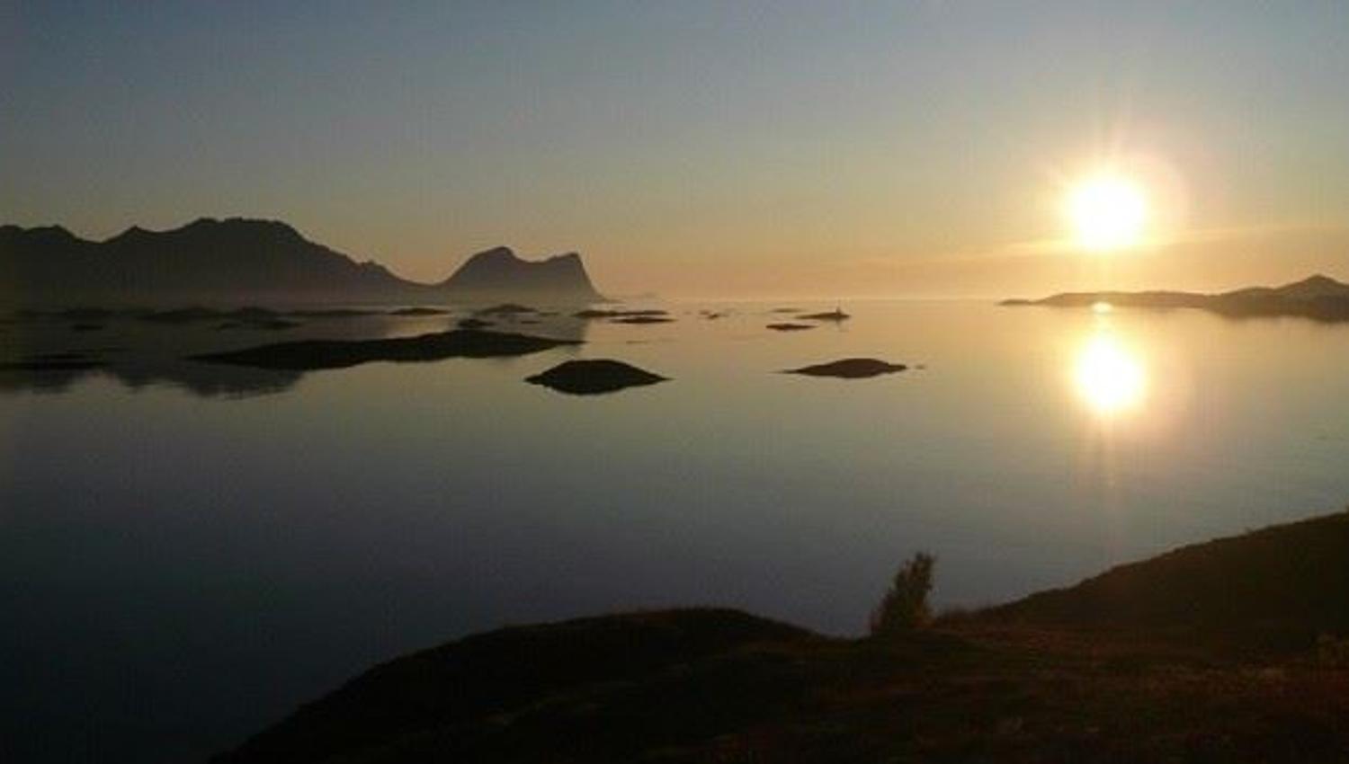 midnattssolen skinner på fjorden