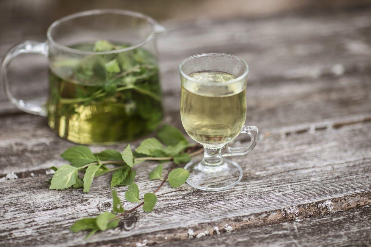 et glass med drikke og en kanne