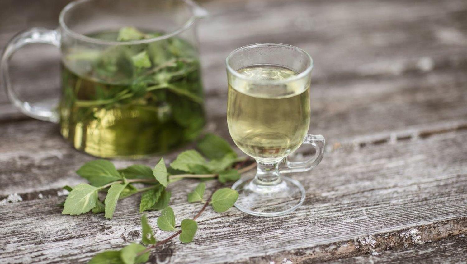 et glass med drikke og en kanne