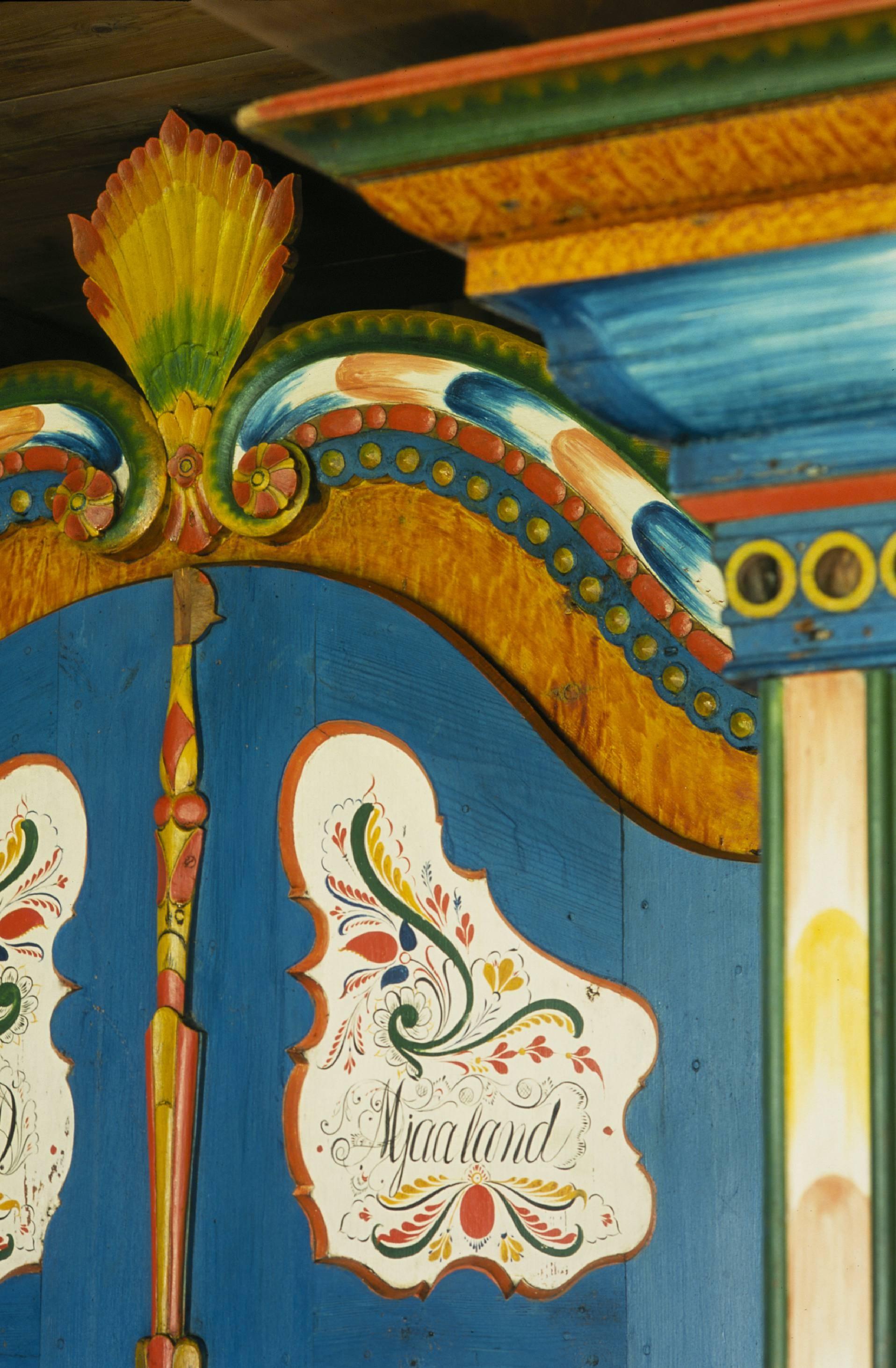 Blå skap med rosemaleri og "Mjaaland" i løkkeskrift