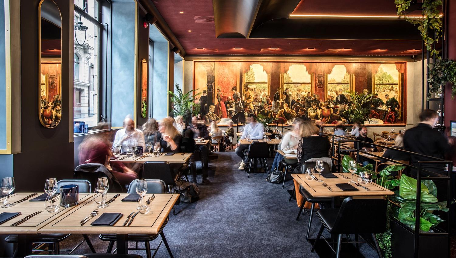 Interiør av Grand Café med mennesker som spiser.