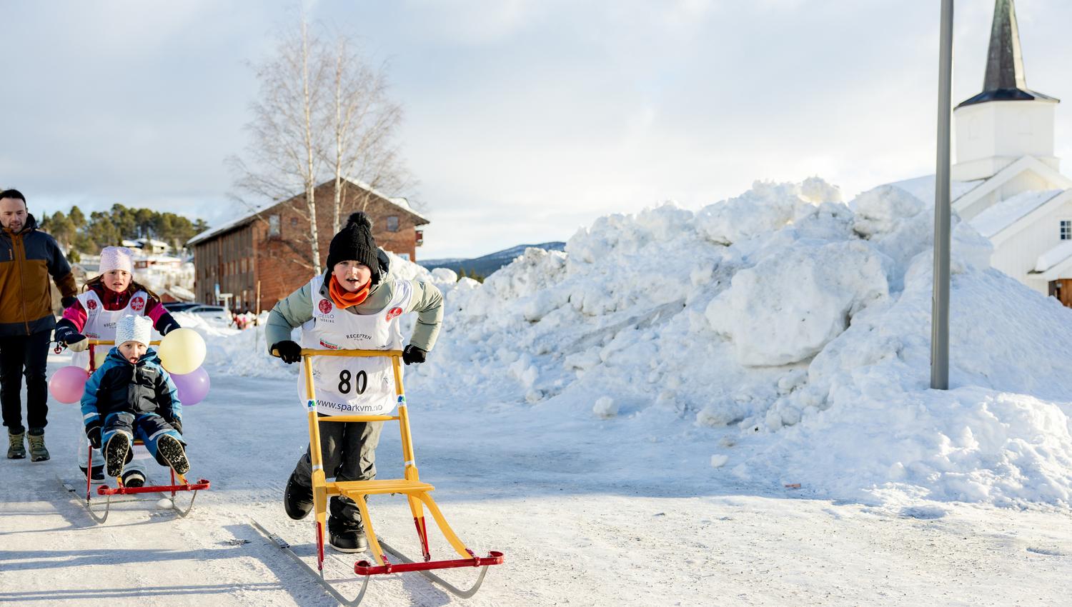 A group of children on kicksleds during the Kicksled World Championship in downtown Geilo.