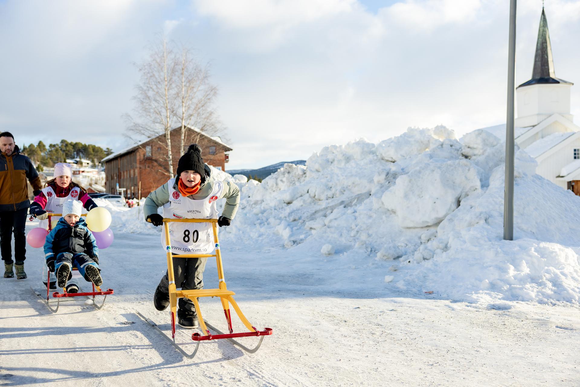 En gruppe barn med sparkstøtting under Spark Verdensmesterskap i Geilo sentrum.