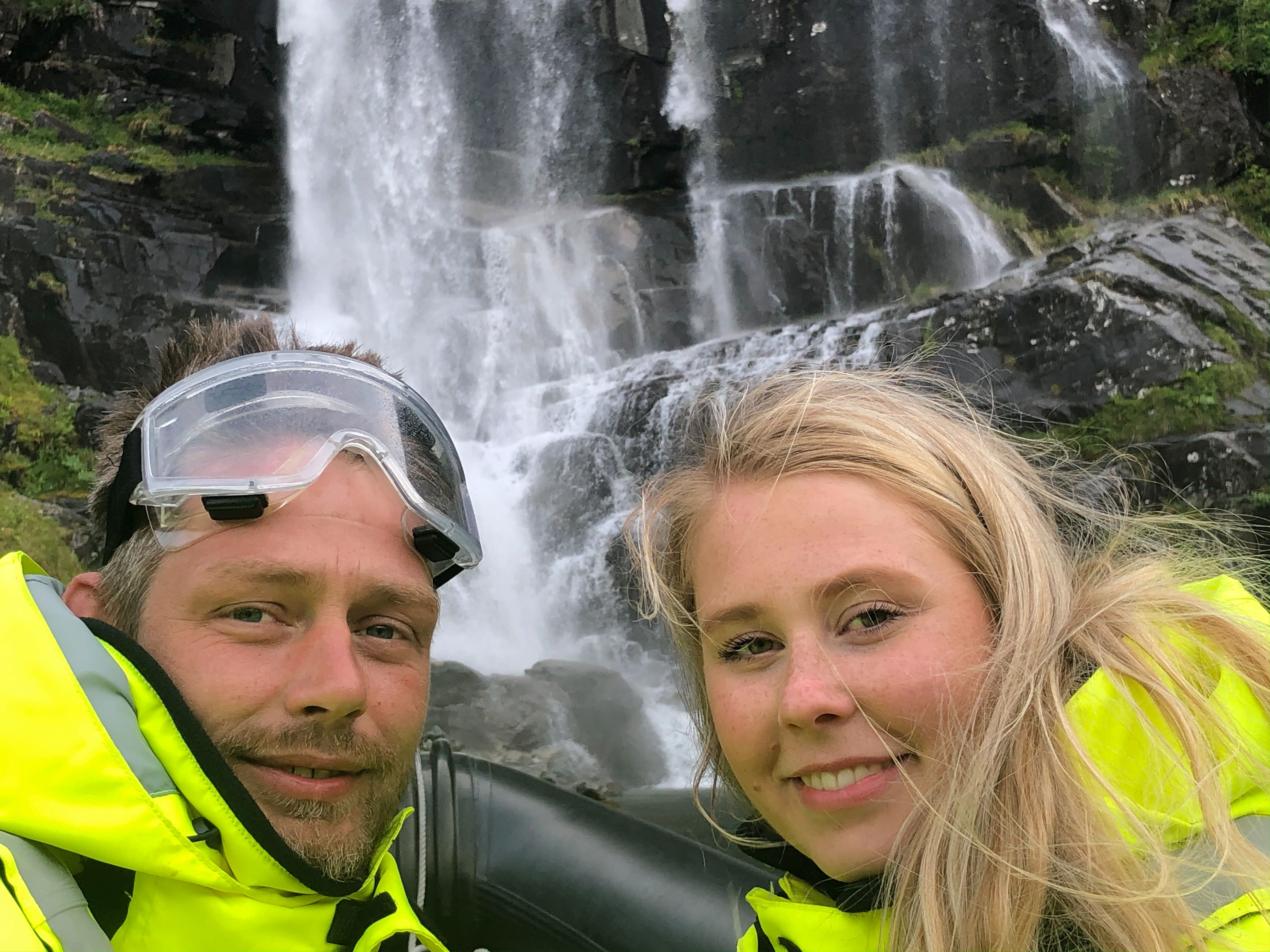 To smilande eventyrarar tek ein selfie framfor eit vakkert fossefall i Hardanger.