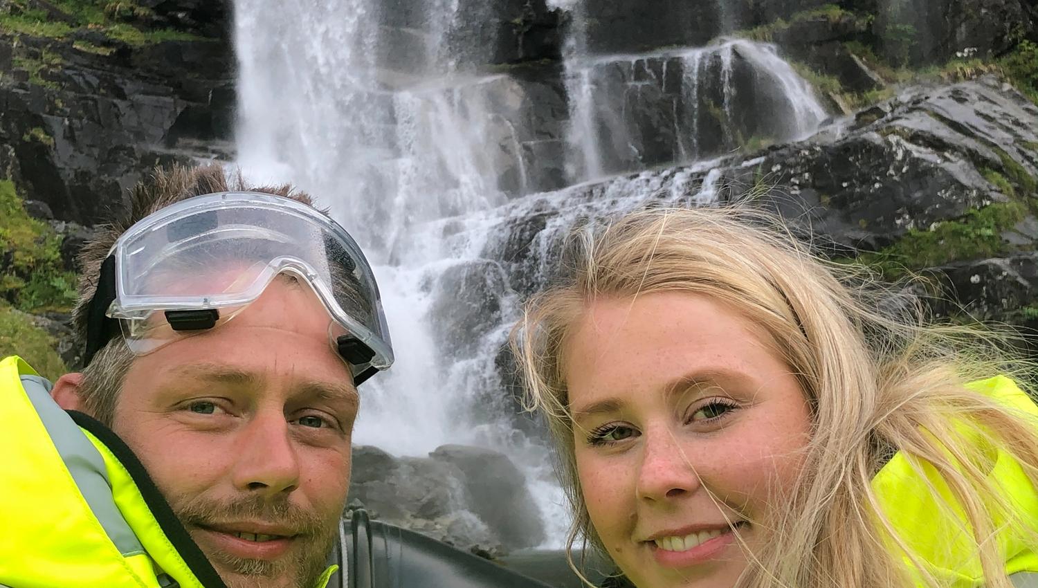 To smilande eventyrarar tek ein selfie framfor eit vakkert fossefall i Hardanger.