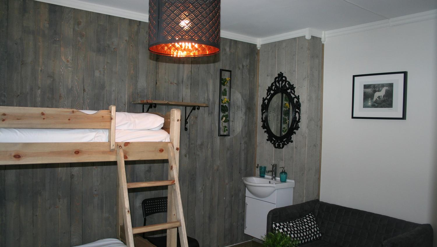 Familierom på Kvamseter Lodge med køyesenger, sofakrok og moderne detaljar.