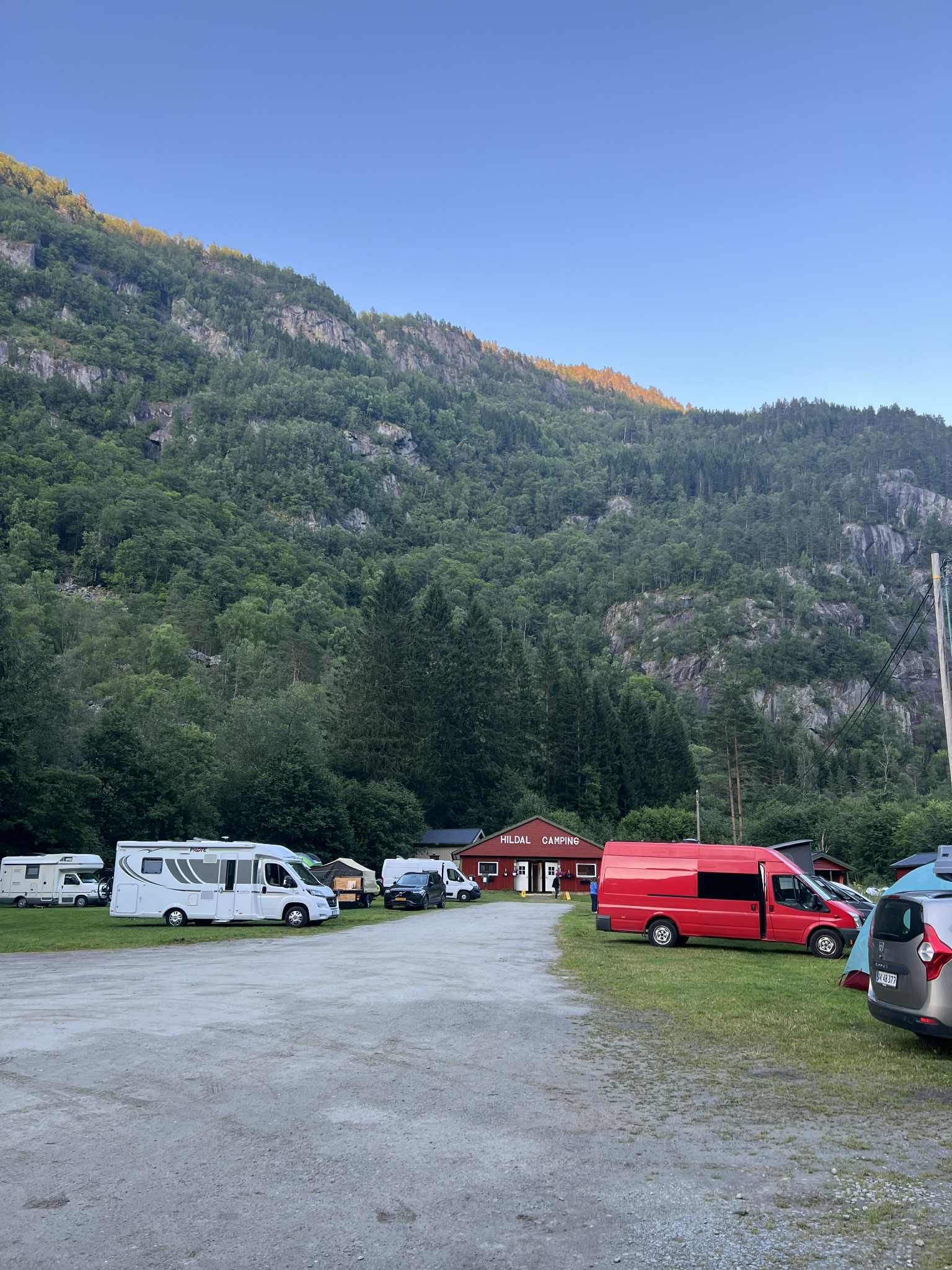 Morgonstemning på Hildal Camping med sollys over fjellsida i Hardanger.