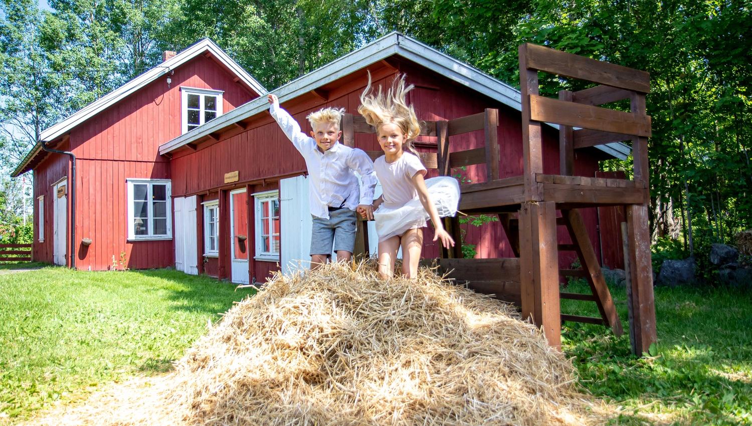 Children jump in the hay