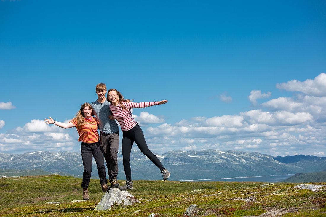 gutt og 2 jenter balanserer på en stein