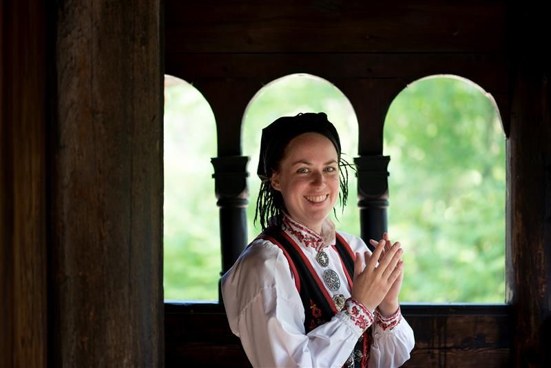 Kvinne i bunad ved Gol stavkirke. Norsk Folkemuseum