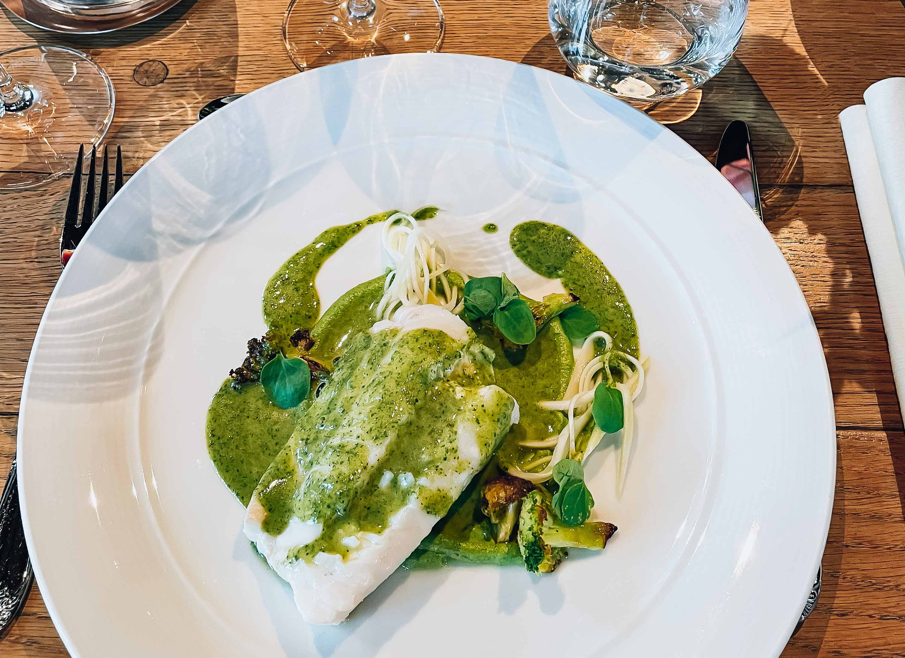 A delicate fish dish with herb sauce served at Siderhuset Ola K in Hardanger. Local flavors and fresh ingredients.