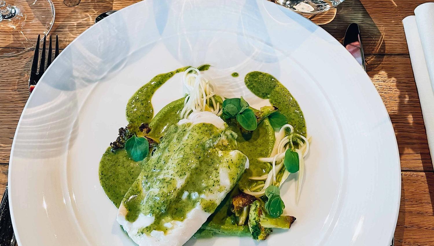 A delicate fish dish with herb sauce served at Siderhuset Ola K in Hardanger. Local flavors and fresh ingredients.