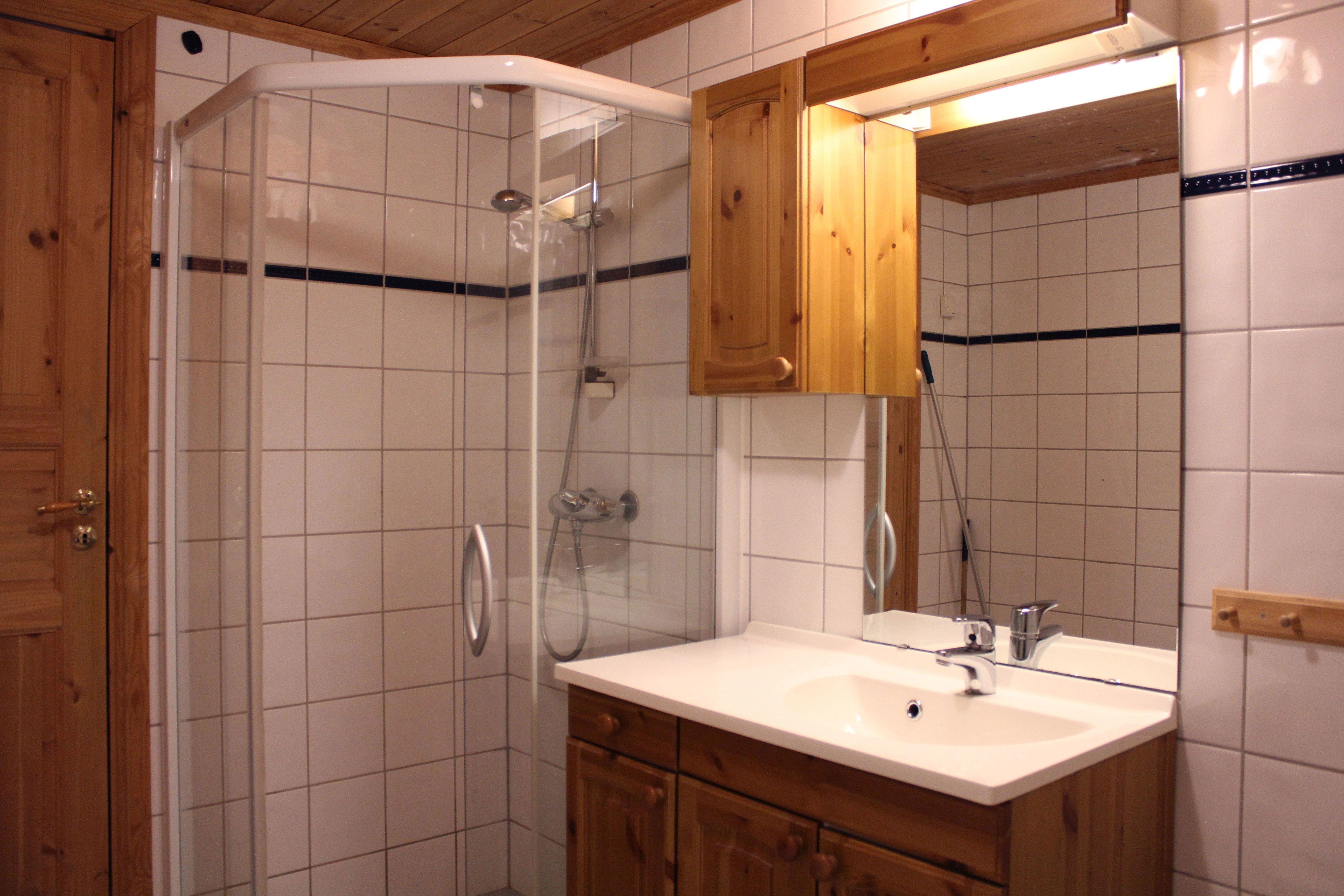 A bathroom with shower and sink.
