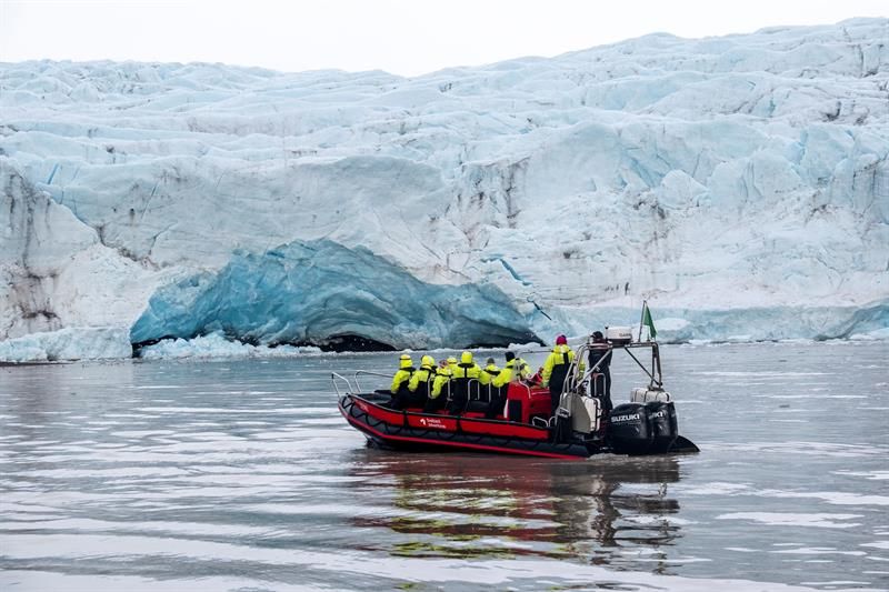 RIB-båt med turister foran isbretunge.