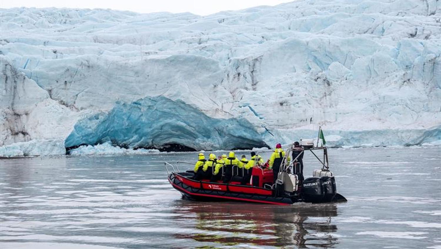 RIB-båt med turister foran isbretunge.