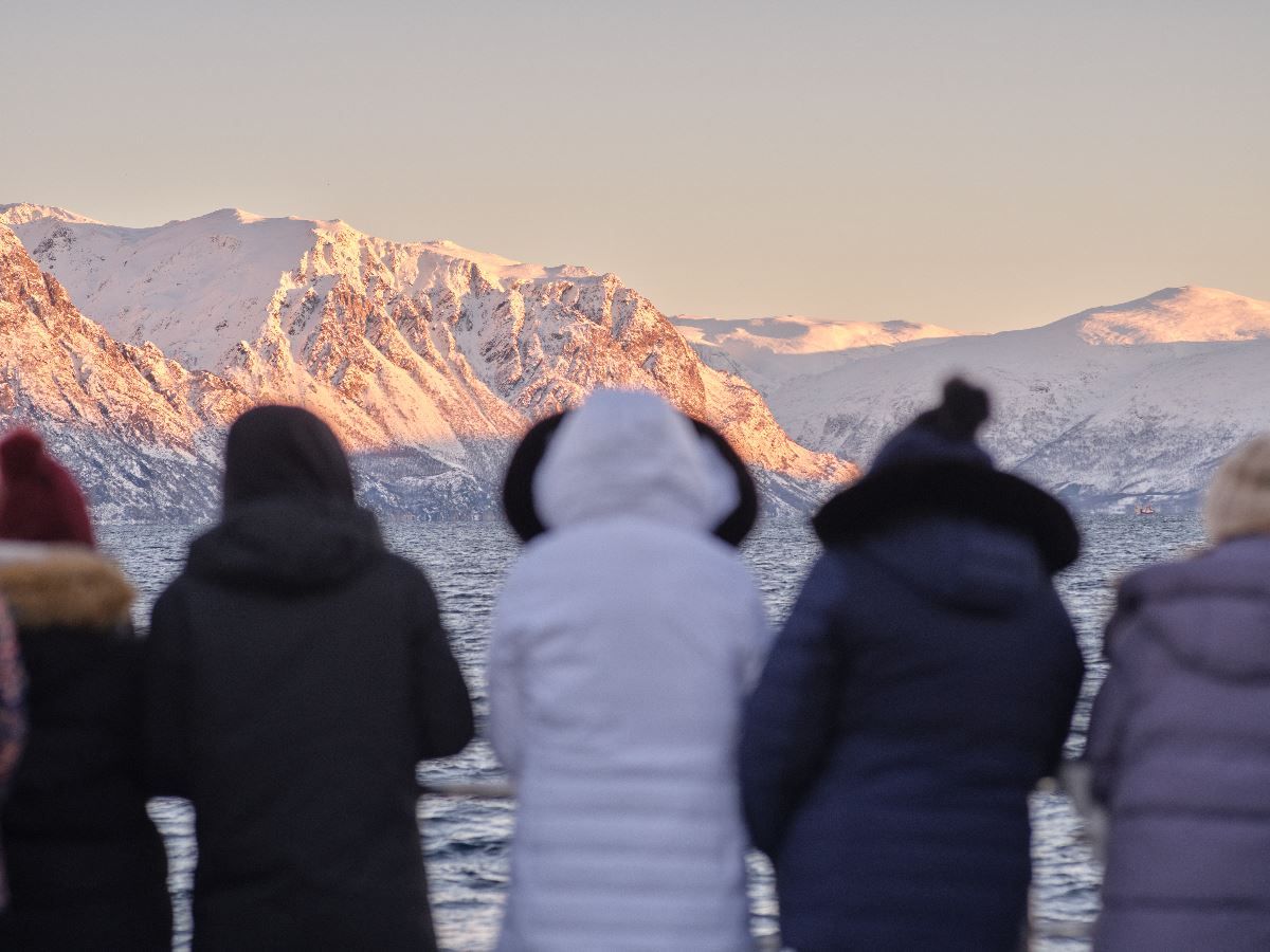 Five people enjoying the view from a boat