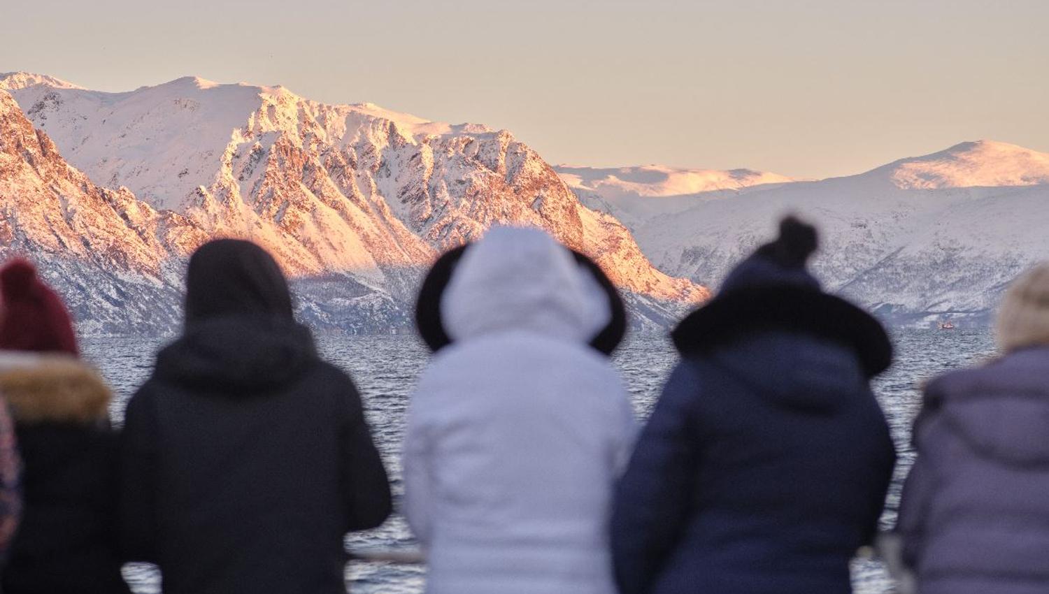 Five people enjoying the view from a boat