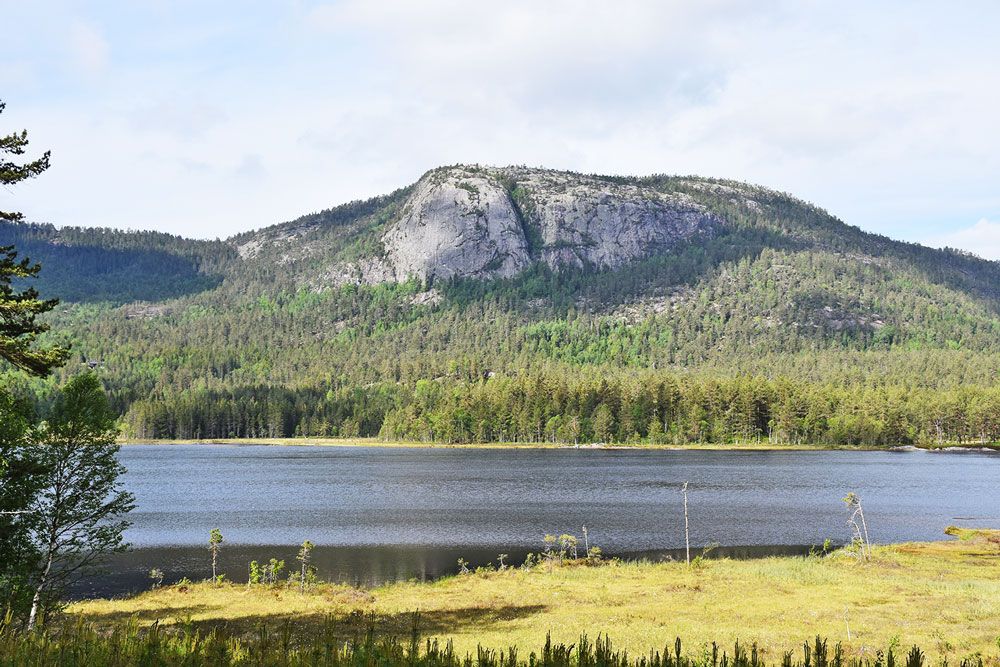 turområde med innsjø og fjell i nærheten av Villmarkseventyret bobilparkering