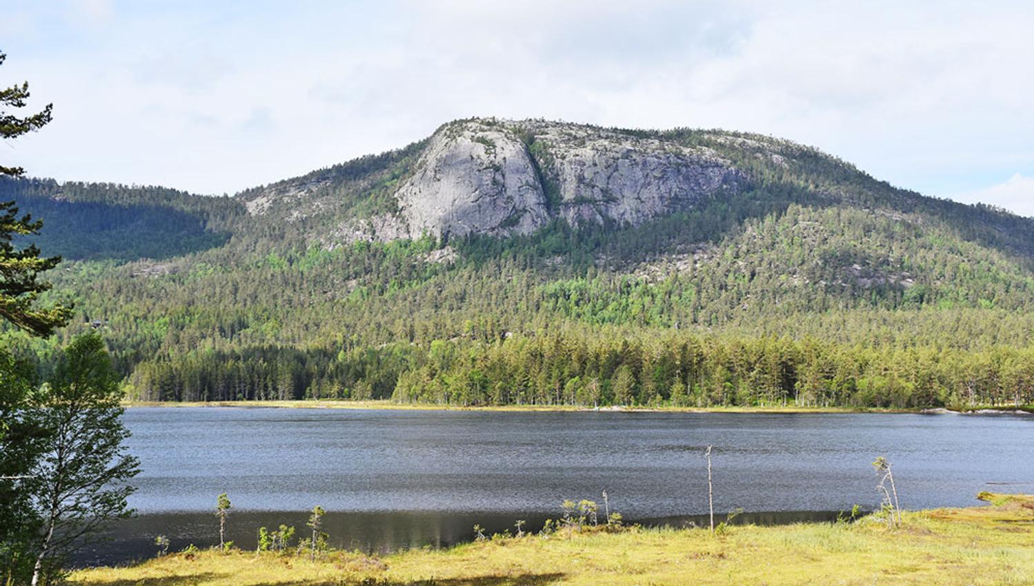 turområde med innsjø og fjell i nærheten av Villmarkseventyret bobilparkering