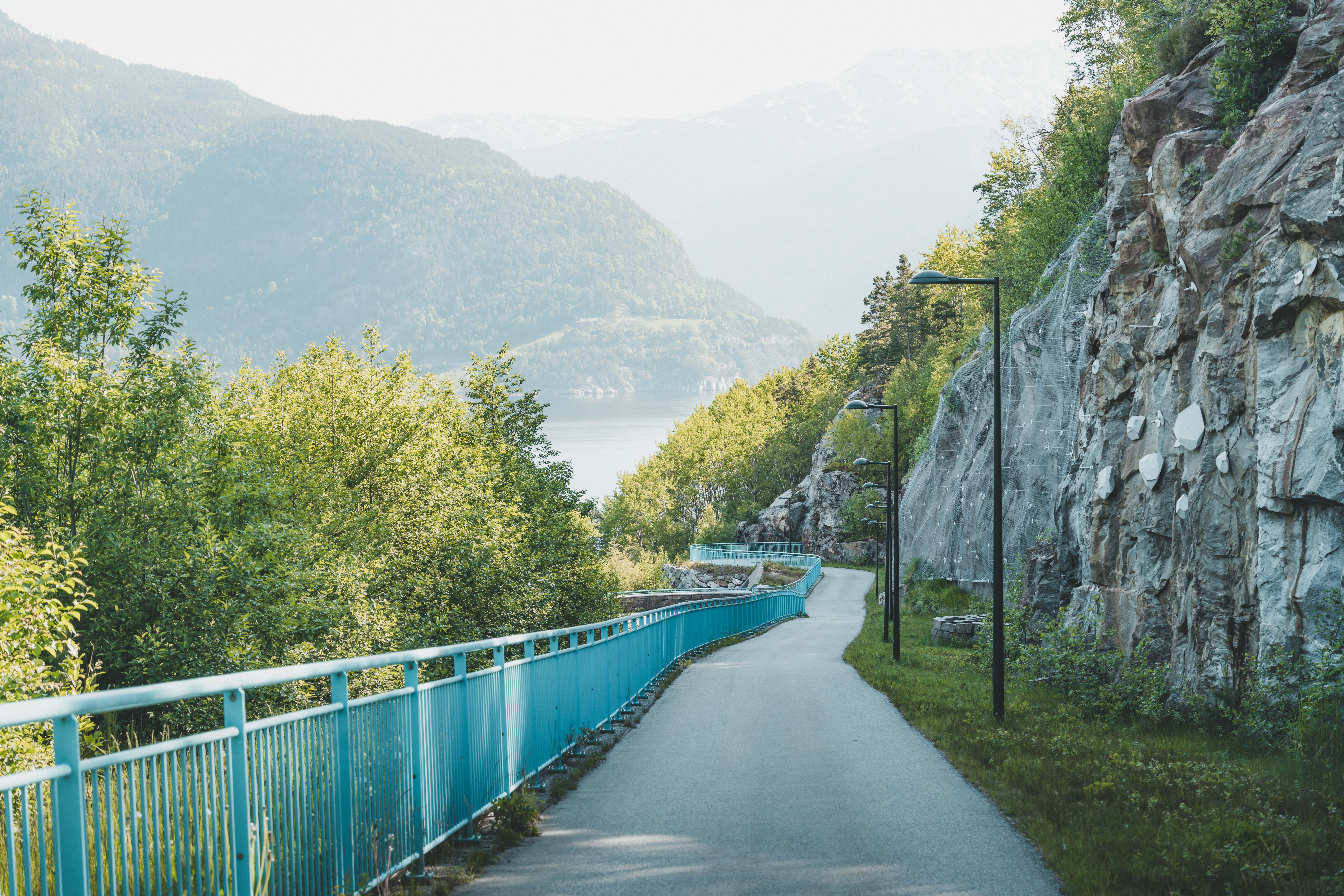 Gangveien ned mot brua i solskinnsvær.