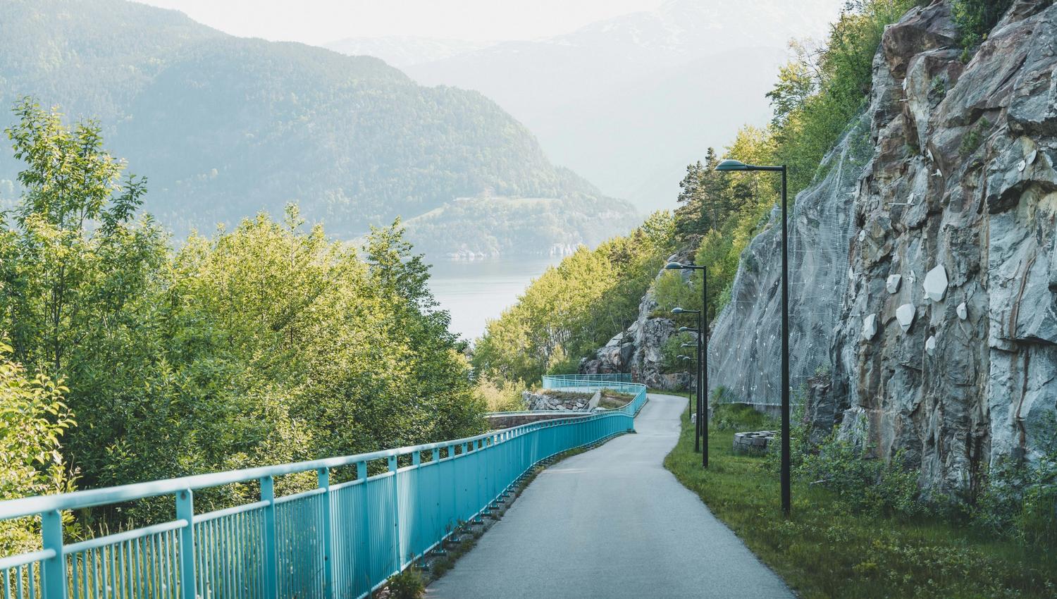Gangveien ned mot brua i solskinnsvær.