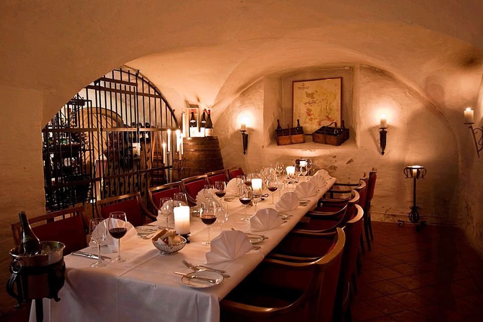 Dekket langbord med hvit duk og vinglass.