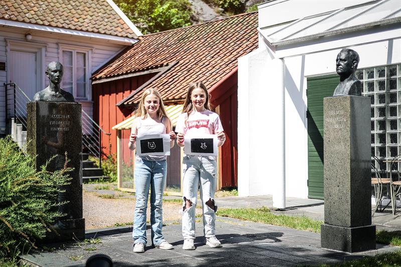 To smilende jenter viser frem tresnittet de har laget