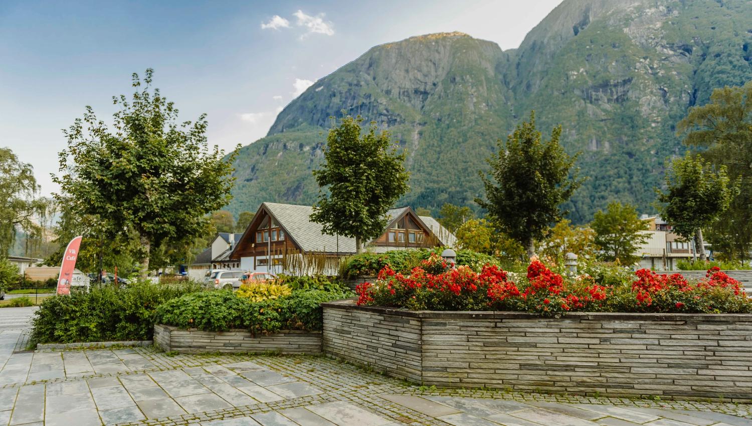 The flower beds at the park, with a building and mountains in the background.