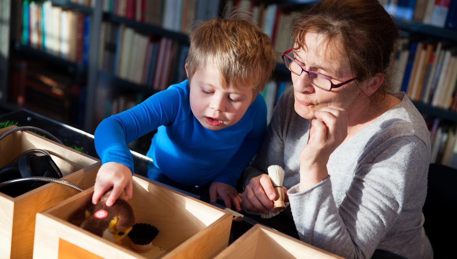 Bestemor og barnebarn oppdagar litterære skattar i ein interaktiv utstillingsboks på Haugesenteret.