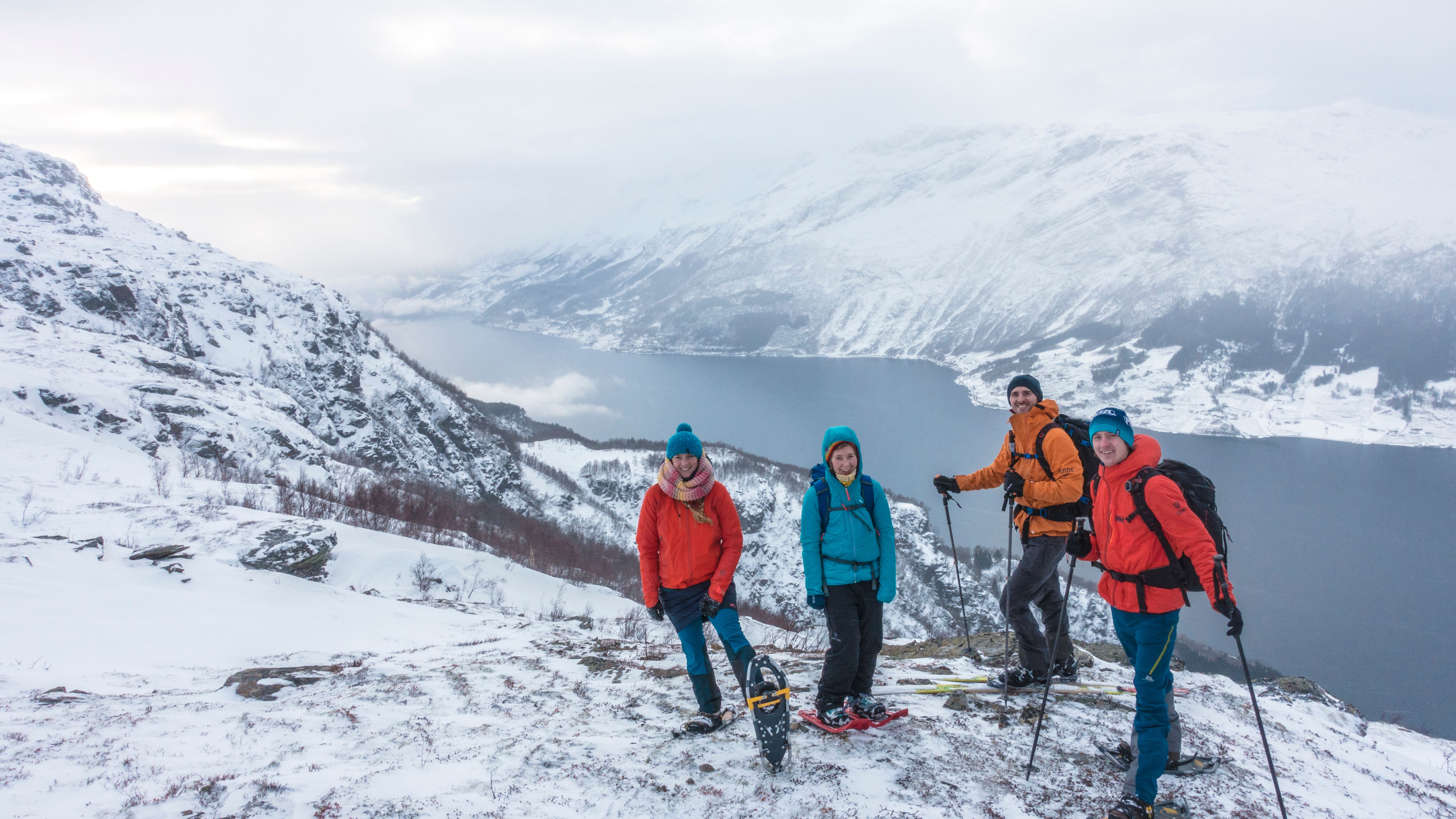 Friends on a snowshoe tour taking a break with a view of the Hardangerfjord.