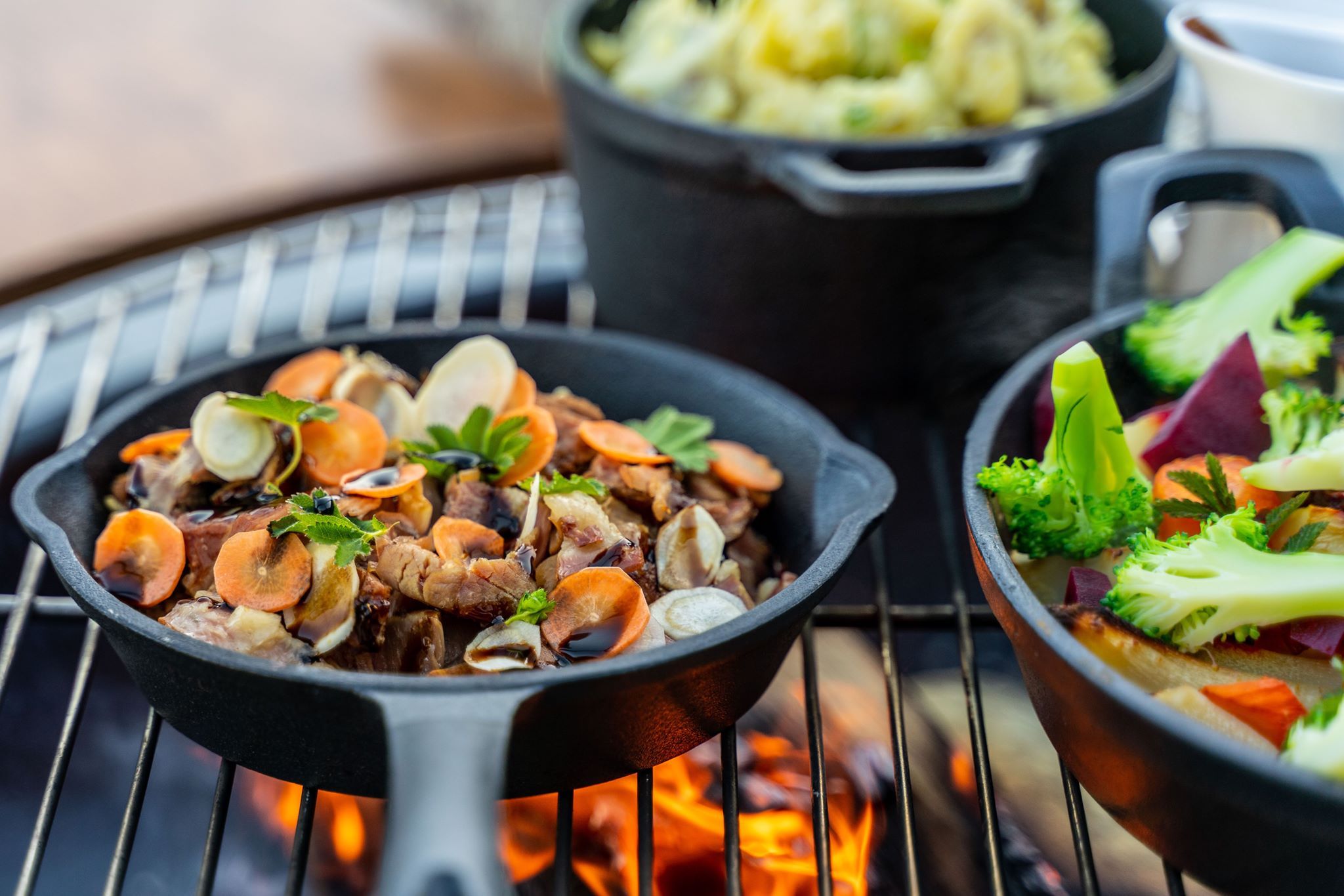 Nærbilete av smakfulle grillrettar med rotgrønsaker og urter.