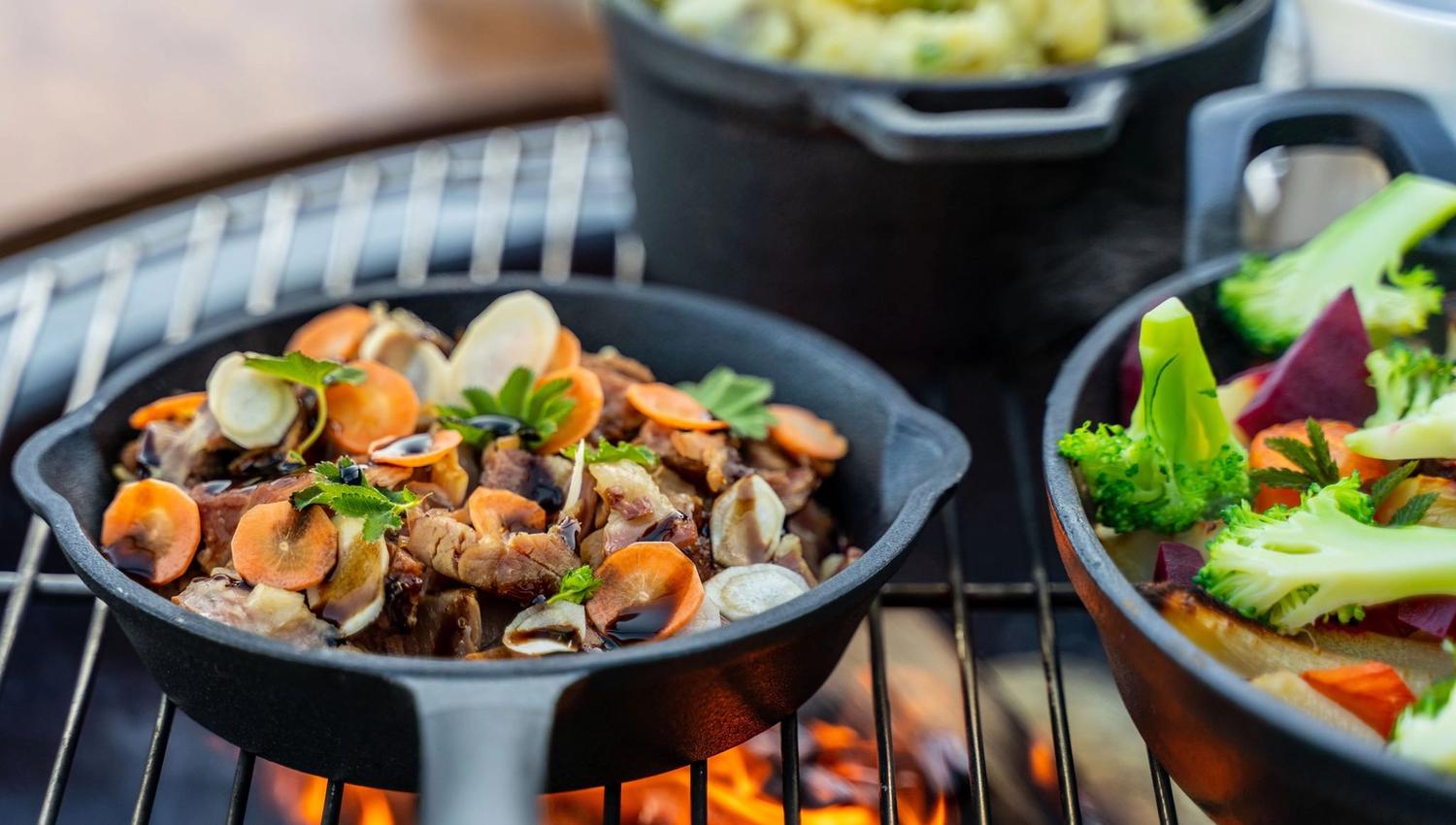Nærbilete av smakfulle grillrettar med rotgrønsaker og urter.