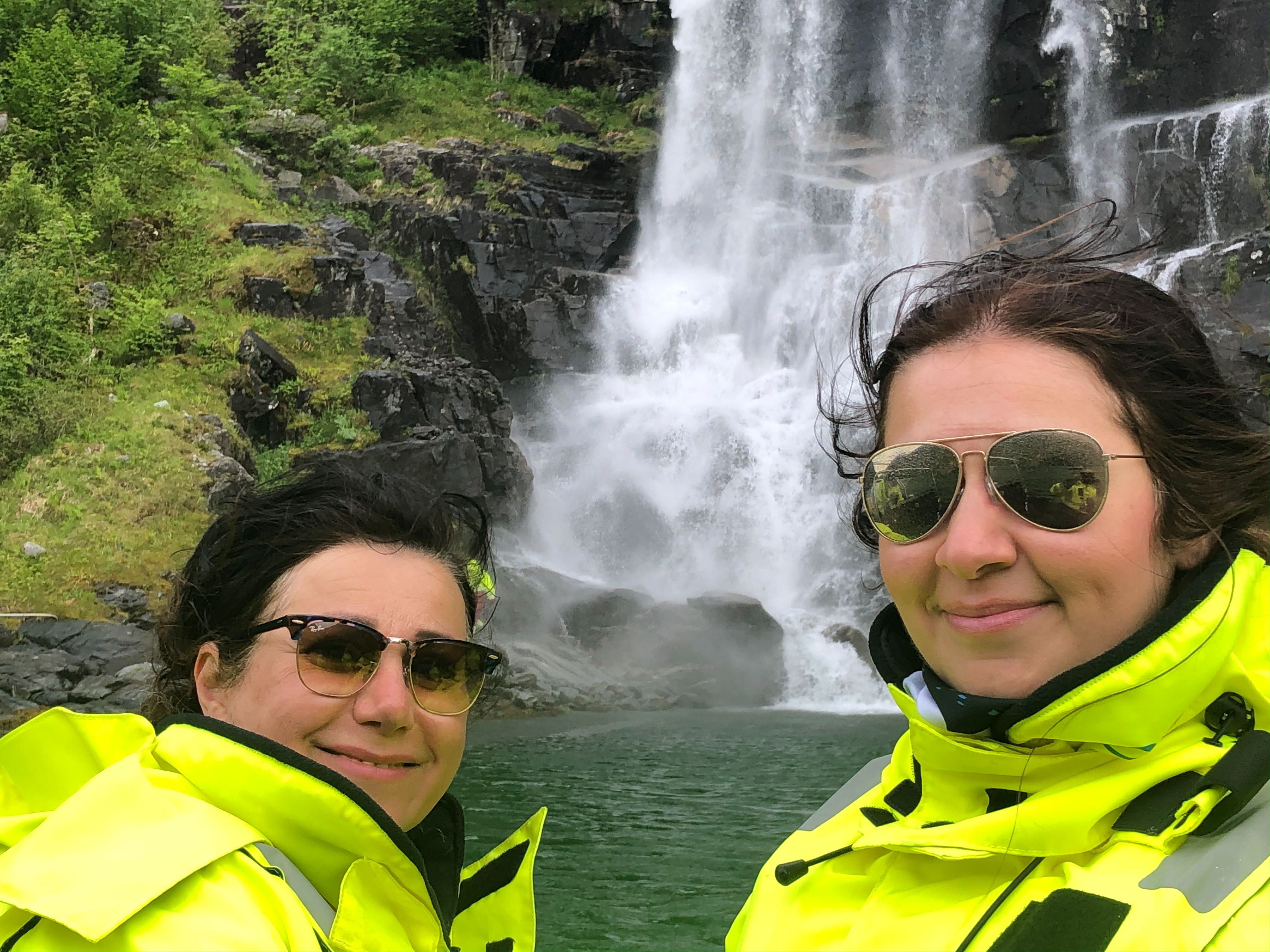 To turistar i gule drakter nyt synet av eit buldrande fossefall på RIB-safari i Hardanger.