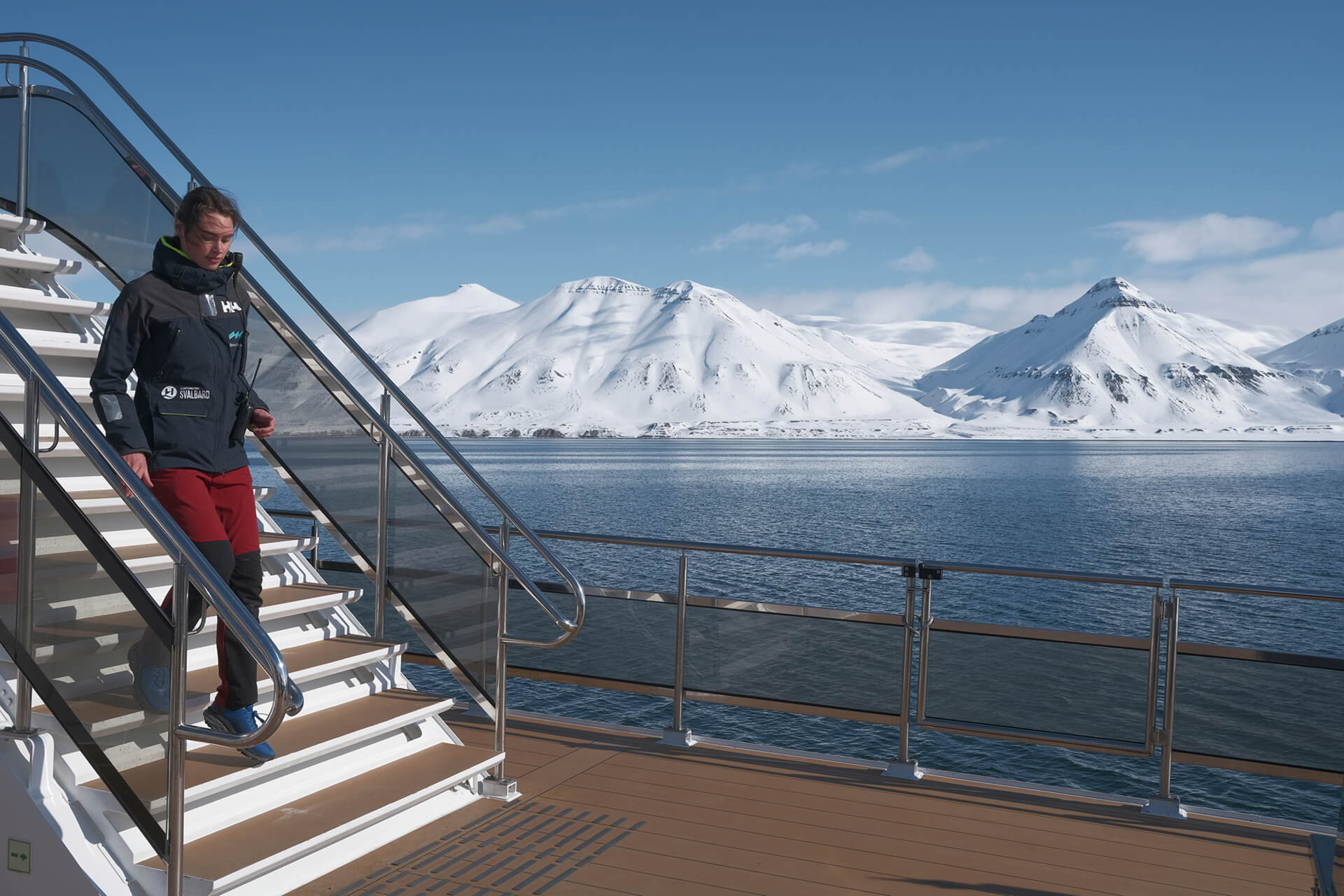 A guide aboard MS Bard walking down a flight of stairs