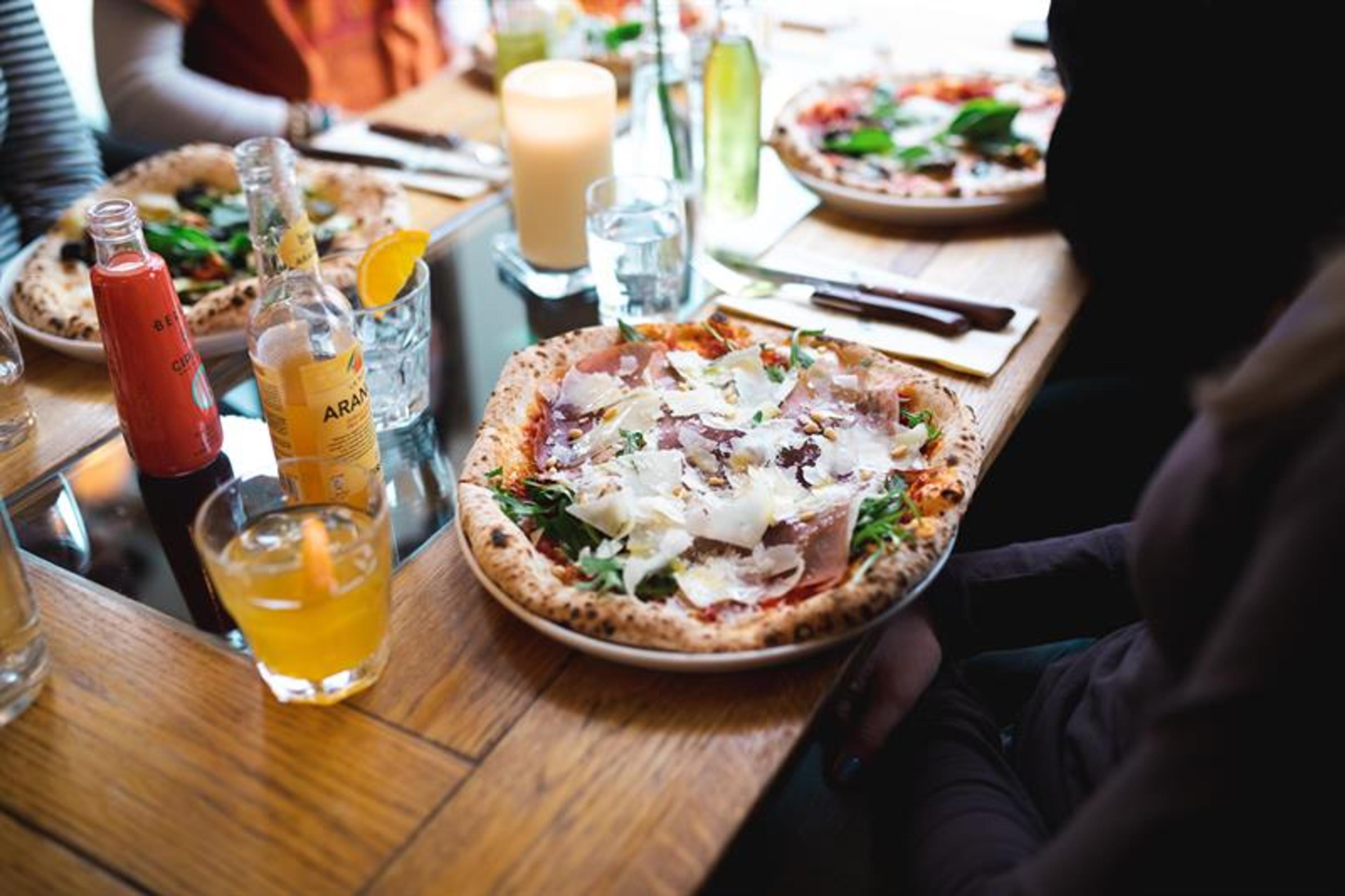 Pizzas and soft drinks on a dining table