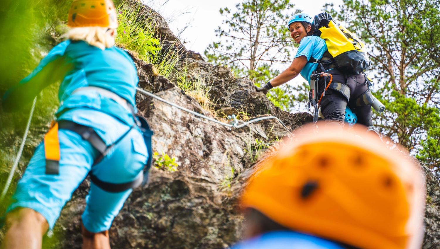 Tre personer på vei opp fjellet i klatreløypa til Via ferrata Haldenkanalen