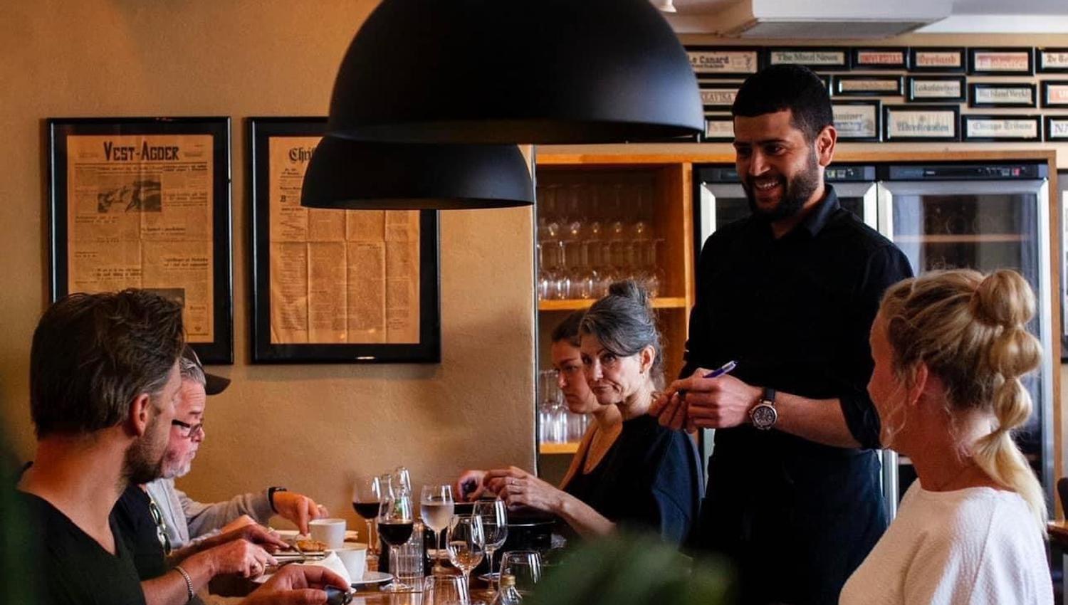 Servitør som serverer smilende gjester