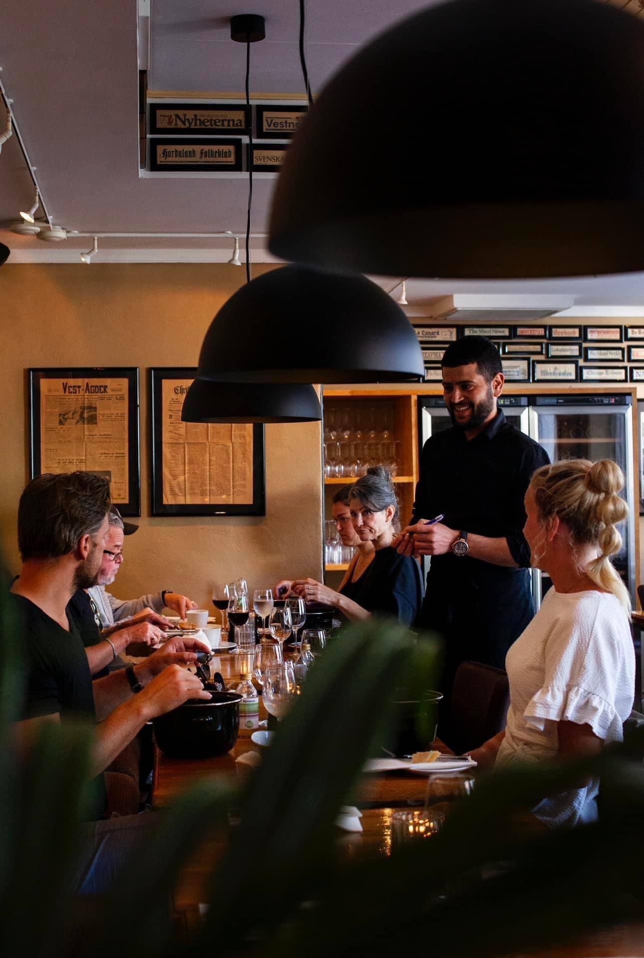 Servitør som serverer smilende gjester