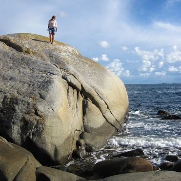 Person på fjell ved havet
