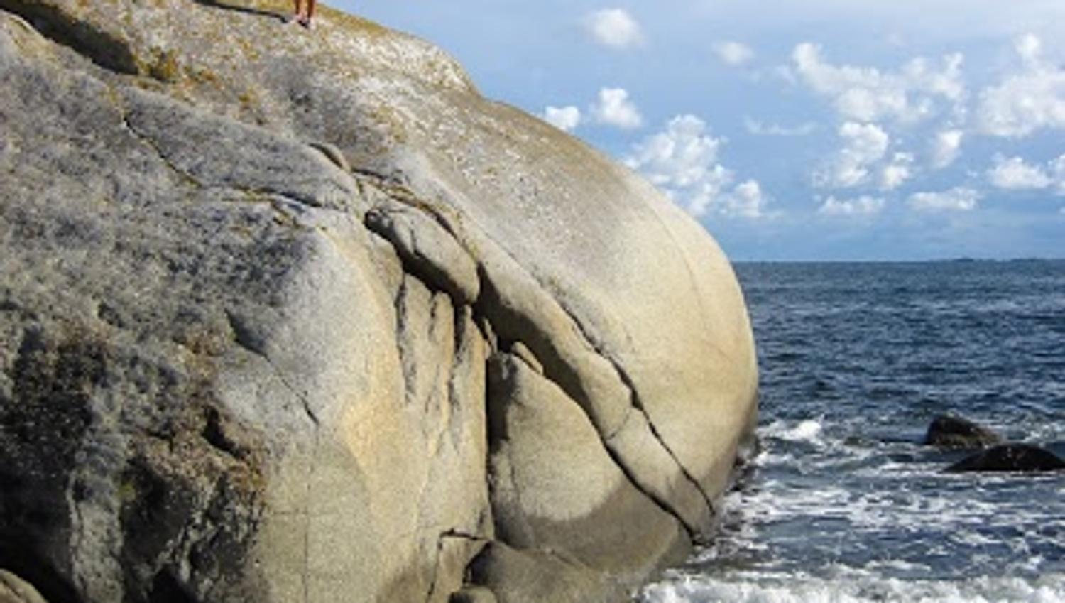 Person på fjell ved havet