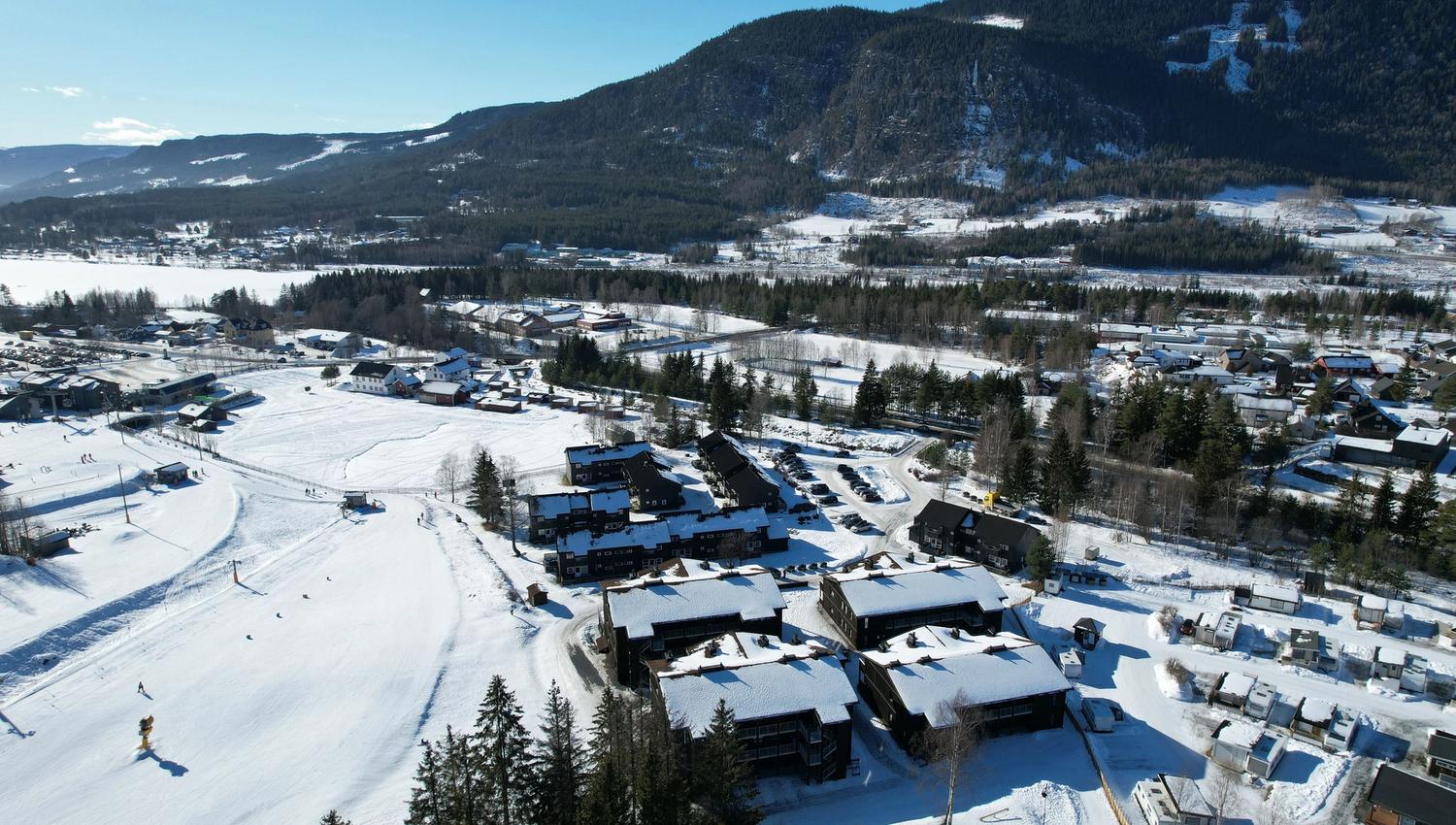 A snow-covered landscape with buildings and trees.