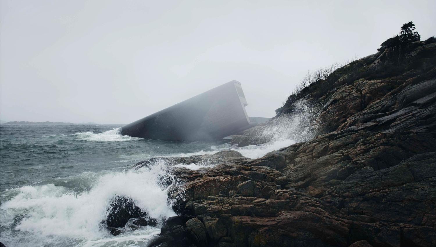 The restaurant in foggy weather with waves crashing against the rocky shore