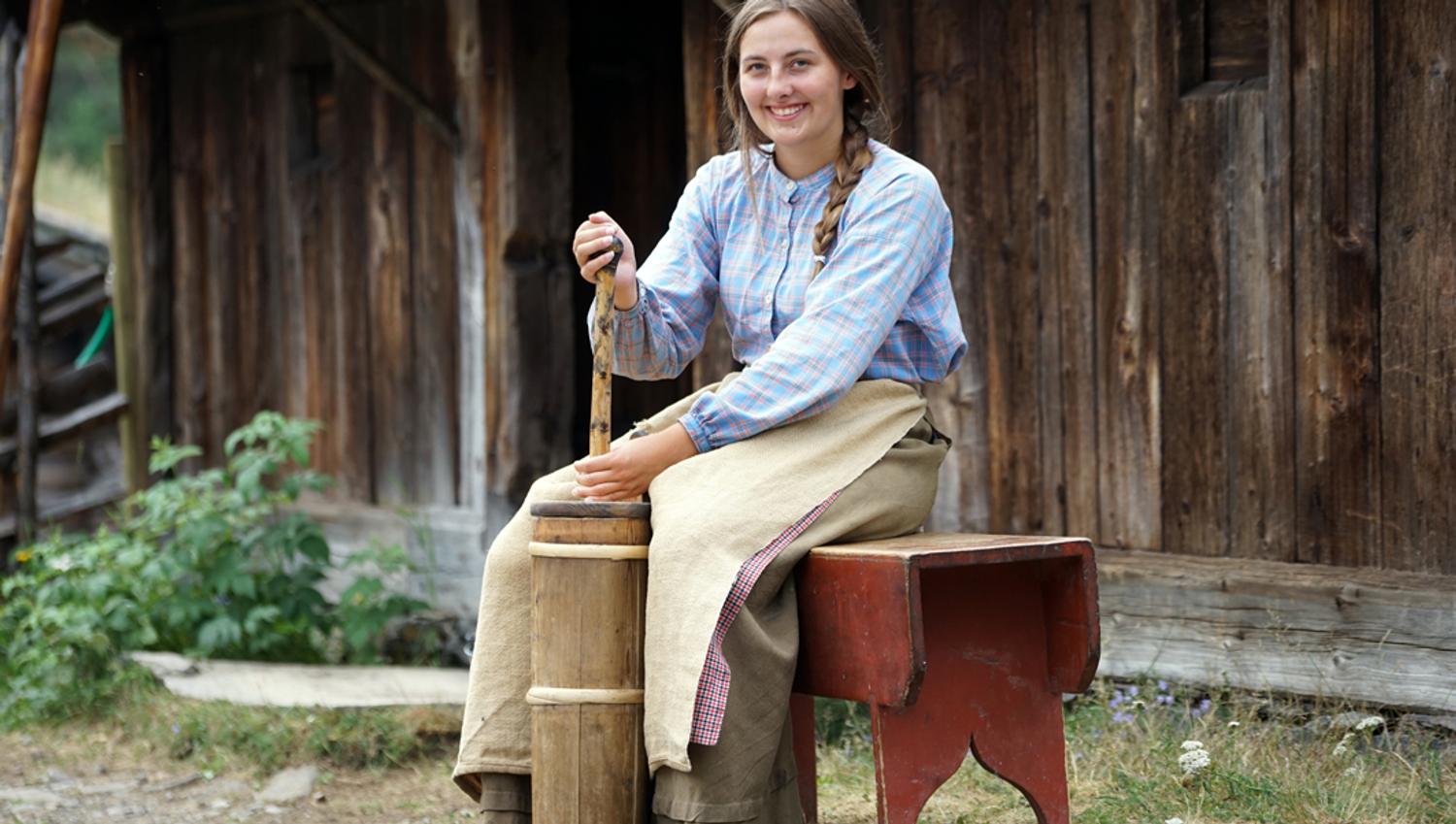 Mountain farm maid making butter.