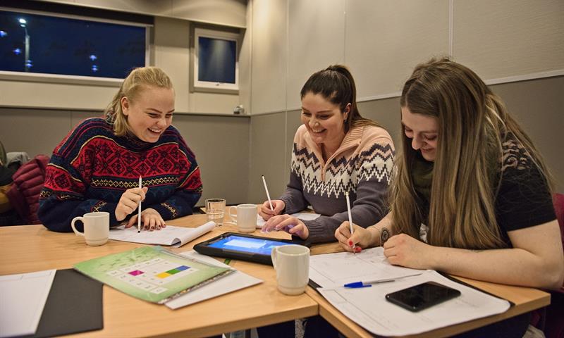 Tre personer som jobber sammen i et konferanserom