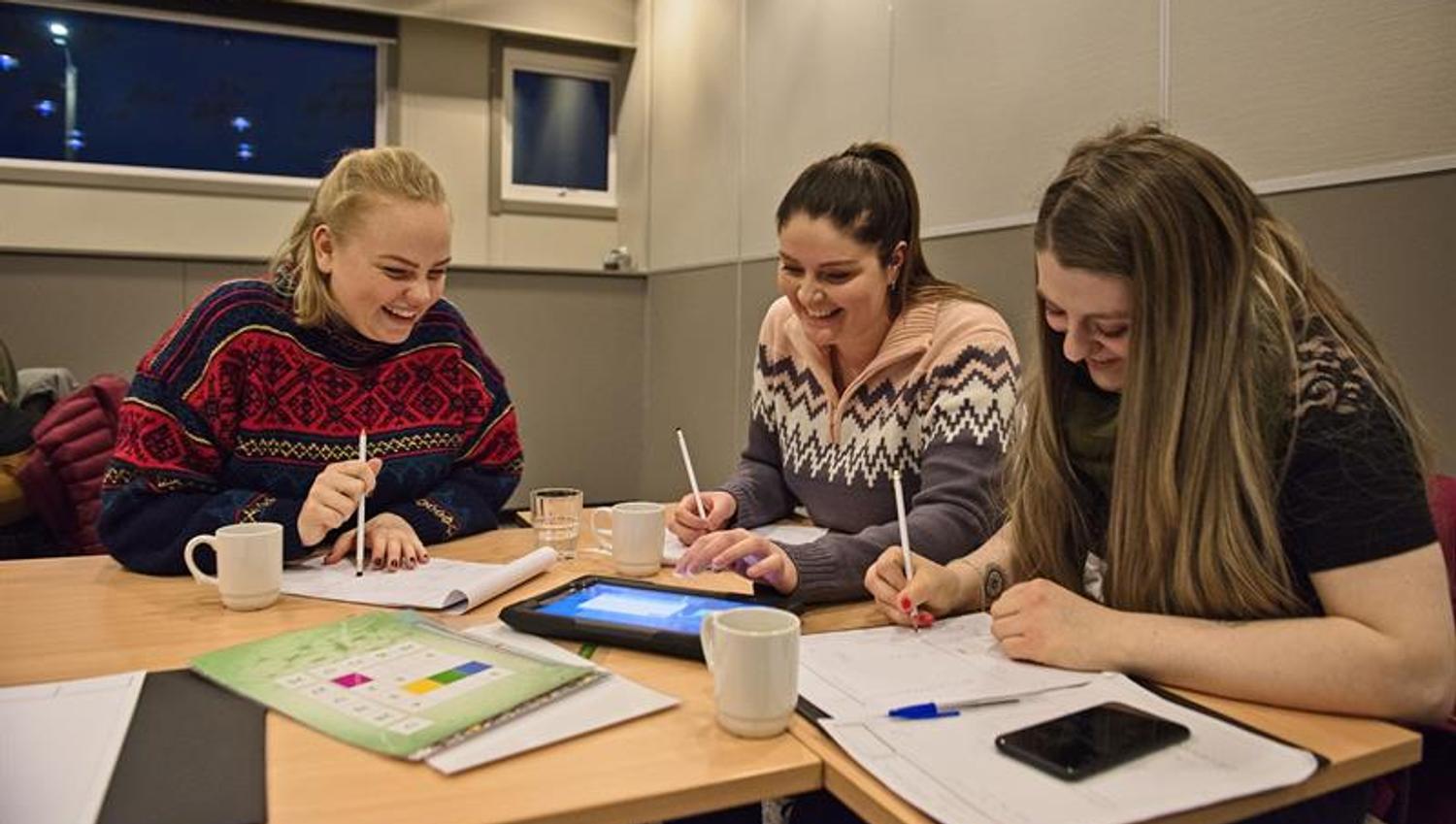 Tre personer som jobber sammen i et konferanserom