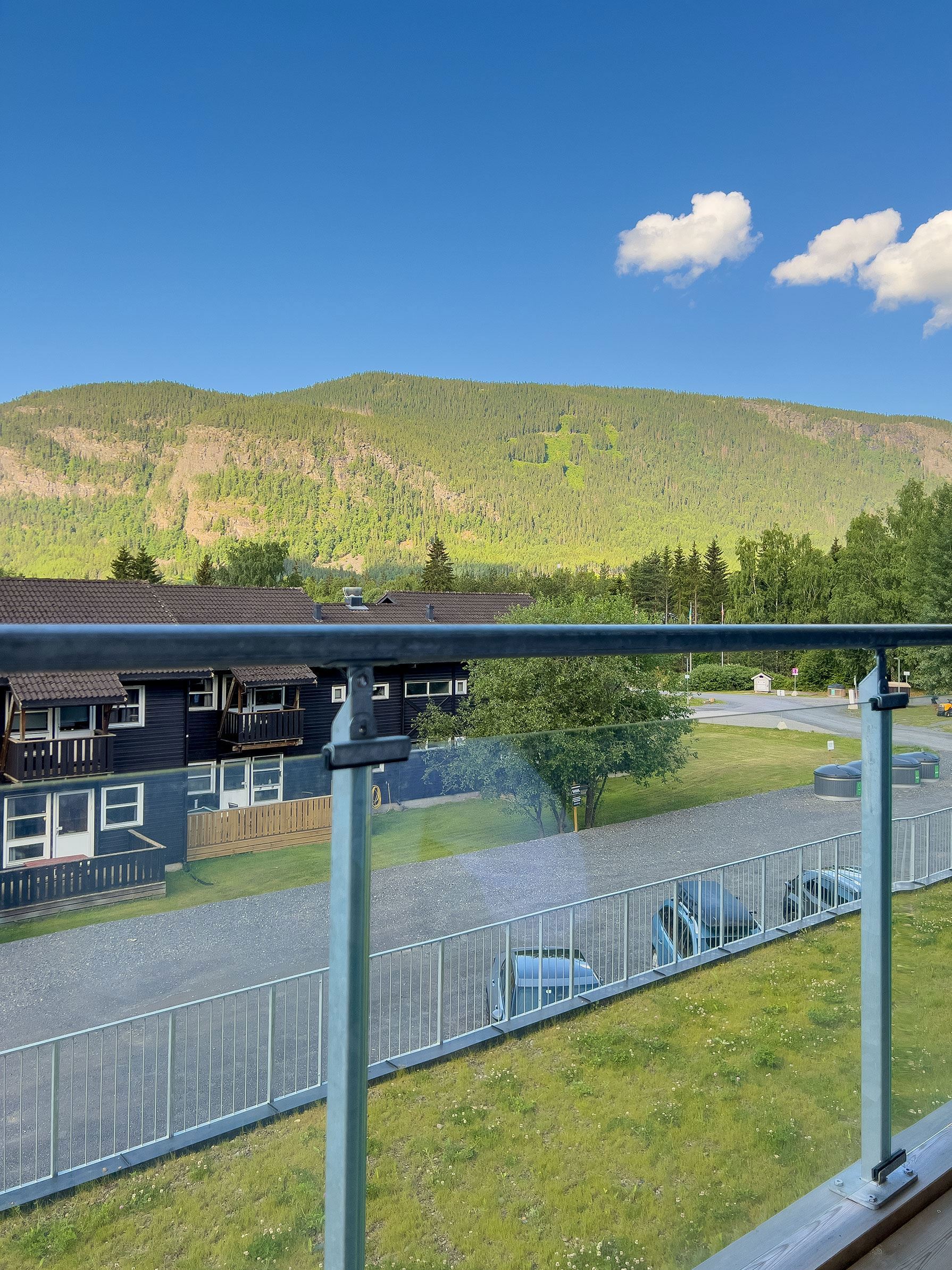 View of a road and a car from a balcony.