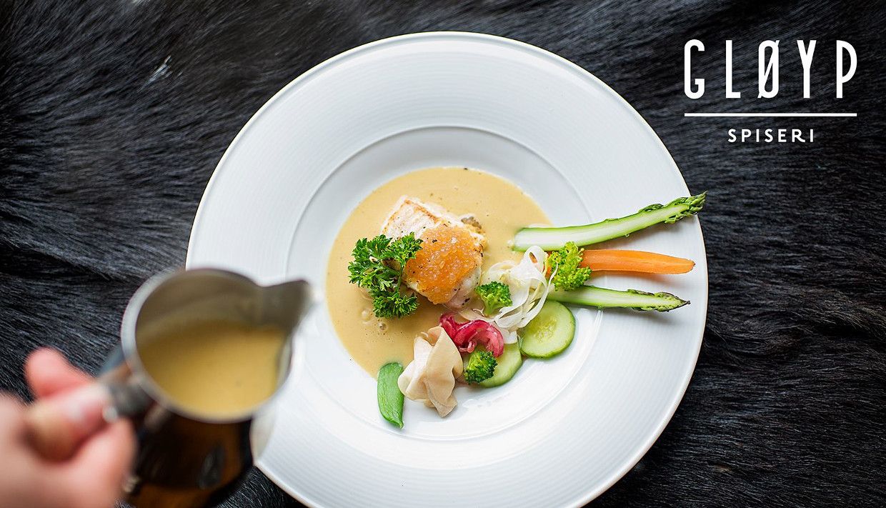 Elegant matrett servert på Gløyp Spiseri med ferske grønsaker og fisk, med saus som vert helt over.