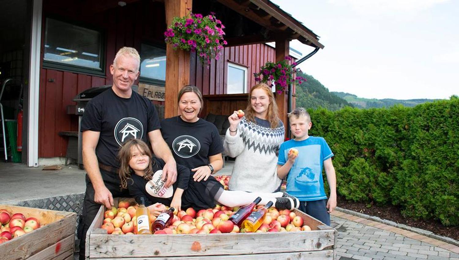 Ein familie nyt haustinga av ferske eple på Spildegarden i Hardanger. Opplev ekte norsk frukttradisjon i hjartet av fjordlandskapet!