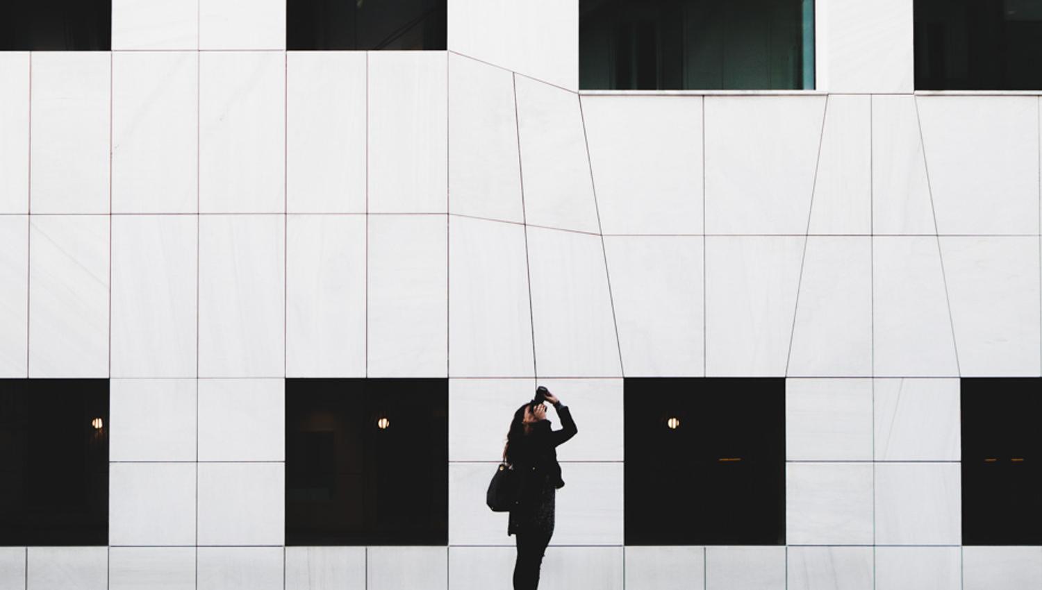 Hvit bygning med person som fotograferer.